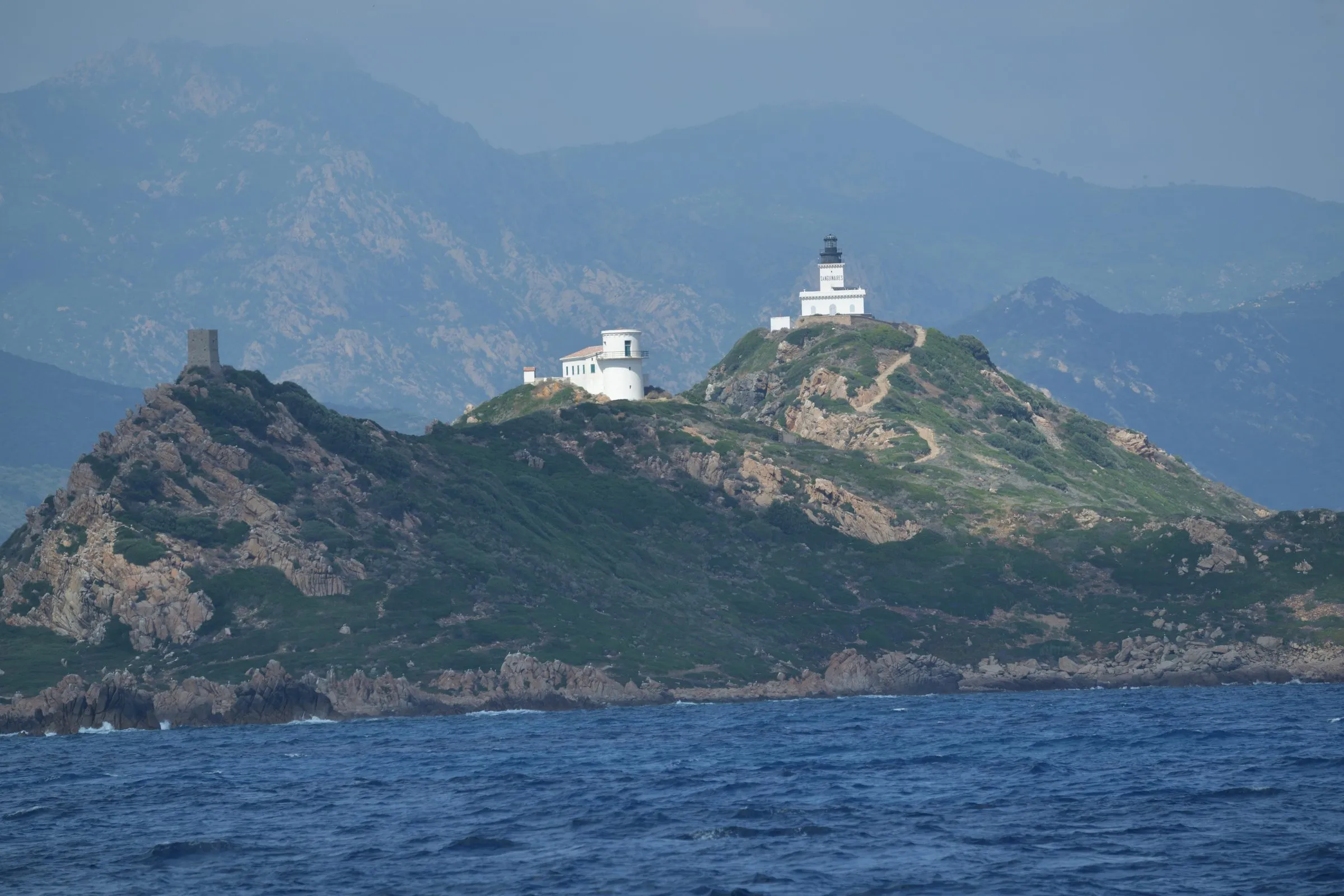 Der Leuchtturm auf der Hauptinsel Mezu Mare der Îles Sanguinaires vor Ajaccio, links der genuesische Turm Tour de la Parata
